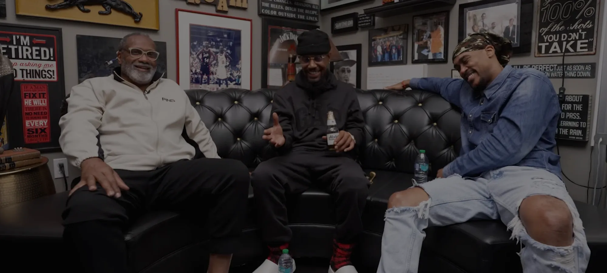 Doc and two guests laughing on the black leather couch in the FBTC studio